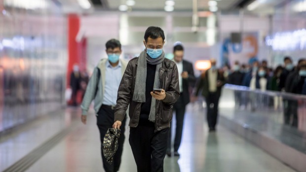 Los viajeros que llevan máscaras protectoras pasan por la estación de Hong Kong.