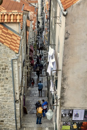 Los turistas caminan por un callejón típico en Dubrovnik, Croacia. Dubrovnik es una de las ciudades más antiguas del Adriático y ...