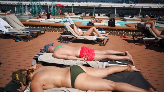Los pasajeros disfrutan del sol en una piscina a bordo del MSC Grandiosa.