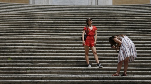 Los turistas toman fotos en la Piazza di Spagna de Roma en junio después de que el gobierno eliminó sus reglas sobre máscaras para exteriores.