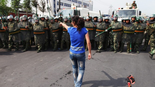 Una mujer uigur protesta frente a policías en Urumqi en 2009.