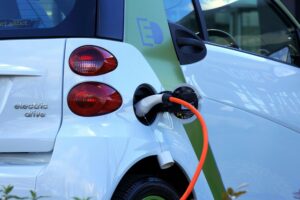 Coche eléctrico moderno cargando en ciudad futuro movilidad