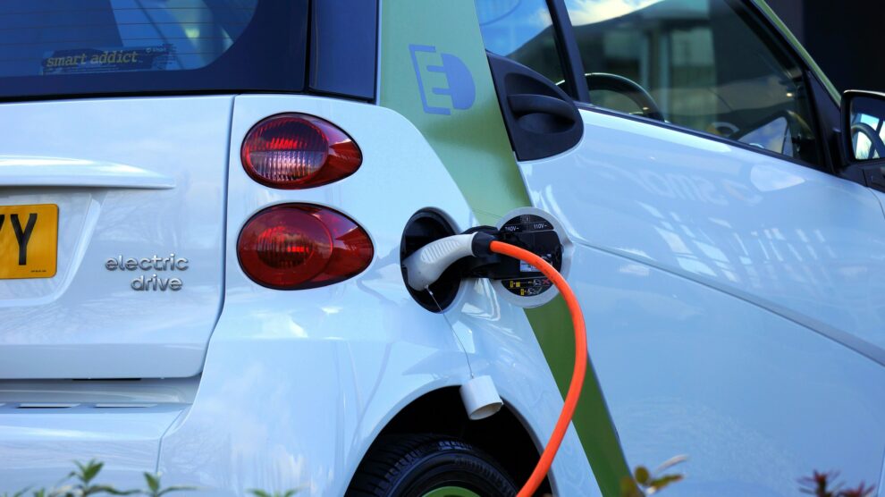 Coche eléctrico moderno cargando en ciudad futuro movilidad