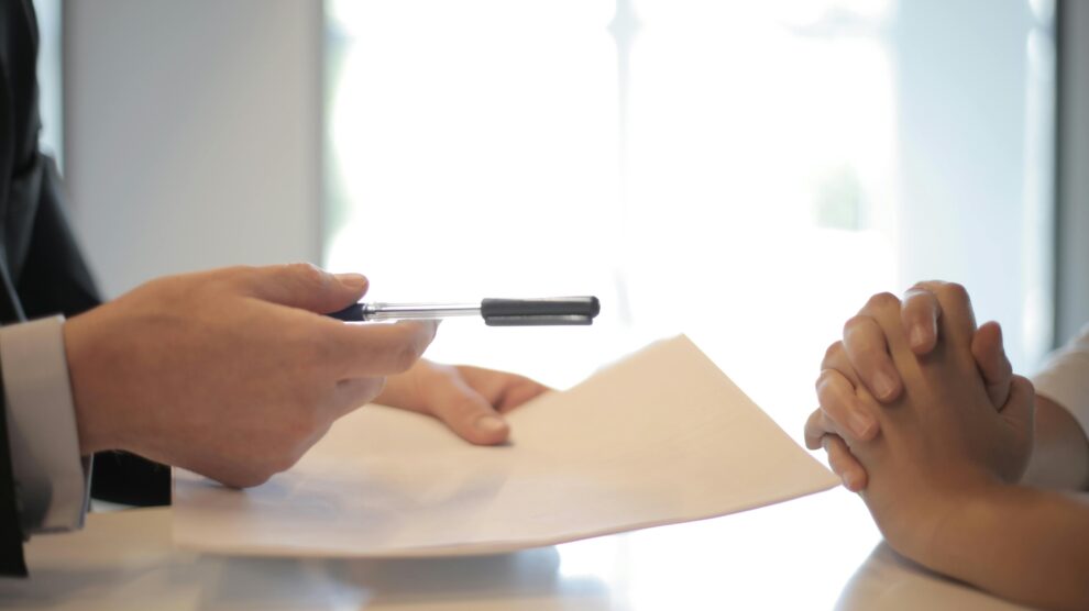 Persona firmando documentos contrato autónomo economía