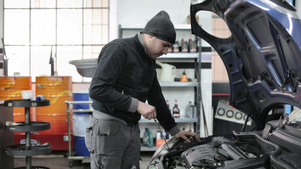 Mecánico revisando coche en taller motor mantenimiento
