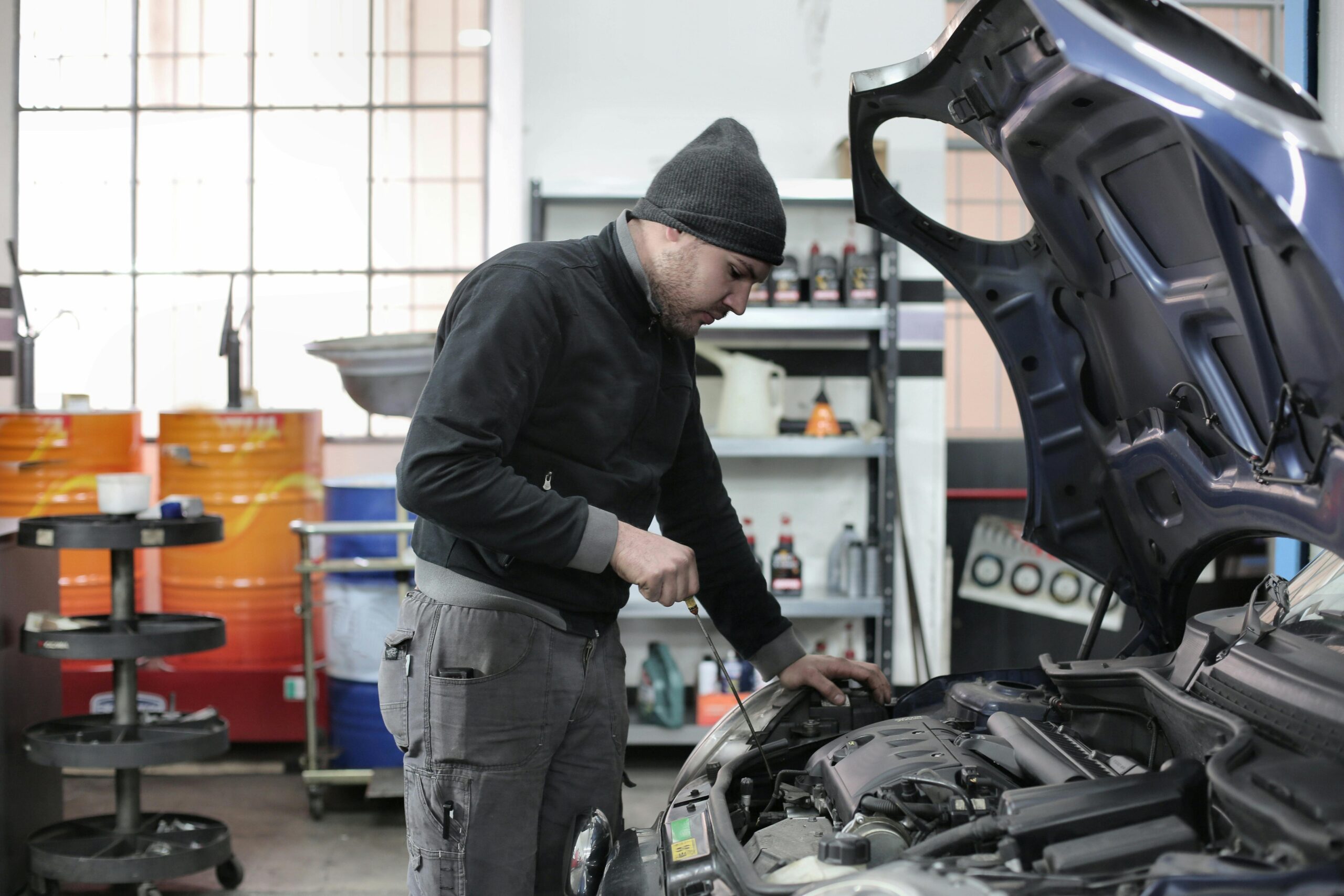 Mecánico cambiando el aceite del motor en taller de coches